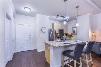 A kitchen with a bar stool and a counter.